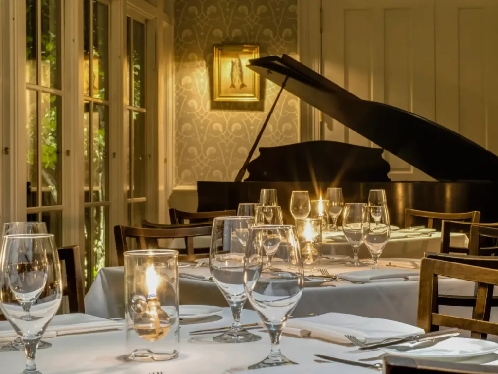 a dining room with a piano in the background