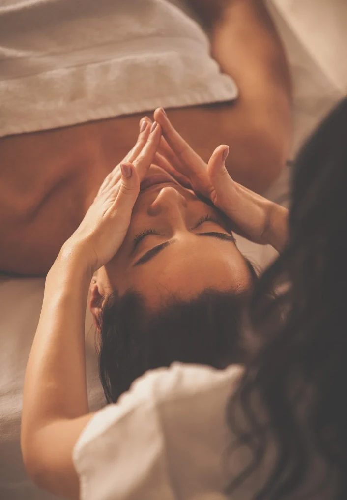 a woman laying on a bed with her hands in the air