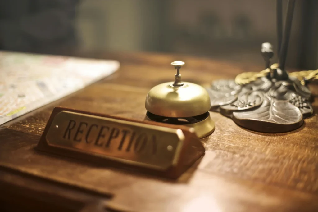 a wooden table topped with a bell and a sign